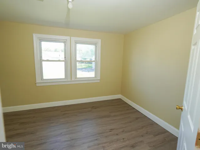 a view of a room with wooden floor and windows