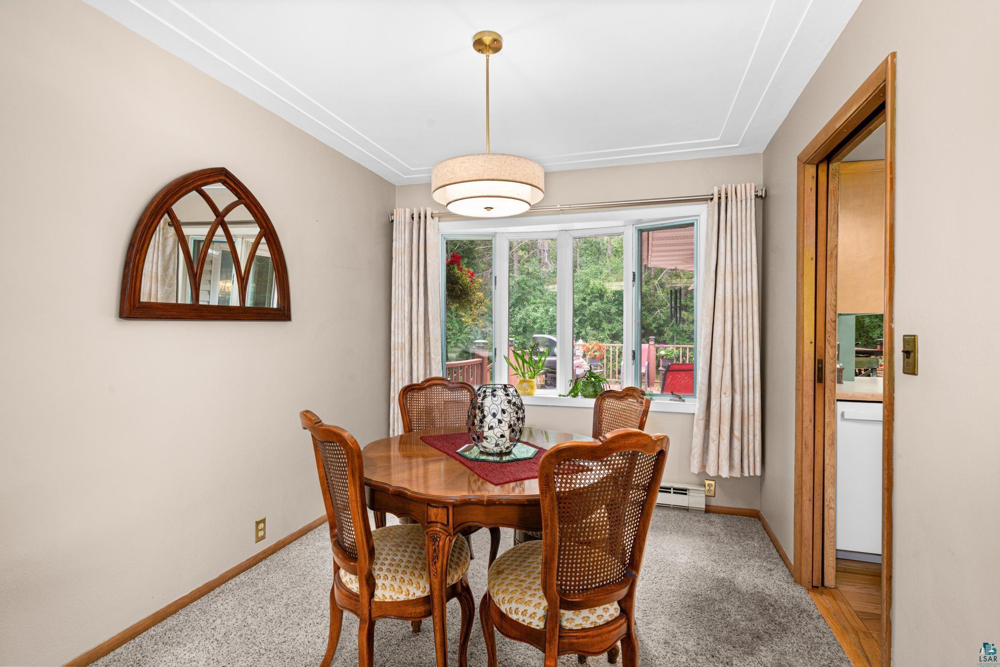 3727 Stebner Road Hermantown, MN 55811 - Photo 9 of 41 Bay window with natural light, textured ceiling detail, wall-to-wall carpeting, and wood-finish trim