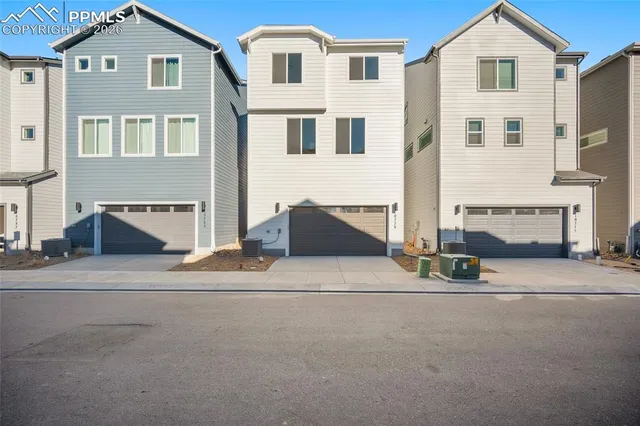 a front view of a house with a road and a garage