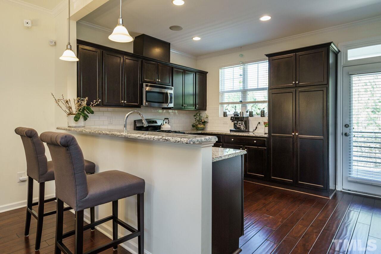1533 Crafton Way Raleigh, NC 27607 - Photo 12 of 28 a kitchen with a table chairs refrigerator and microwave