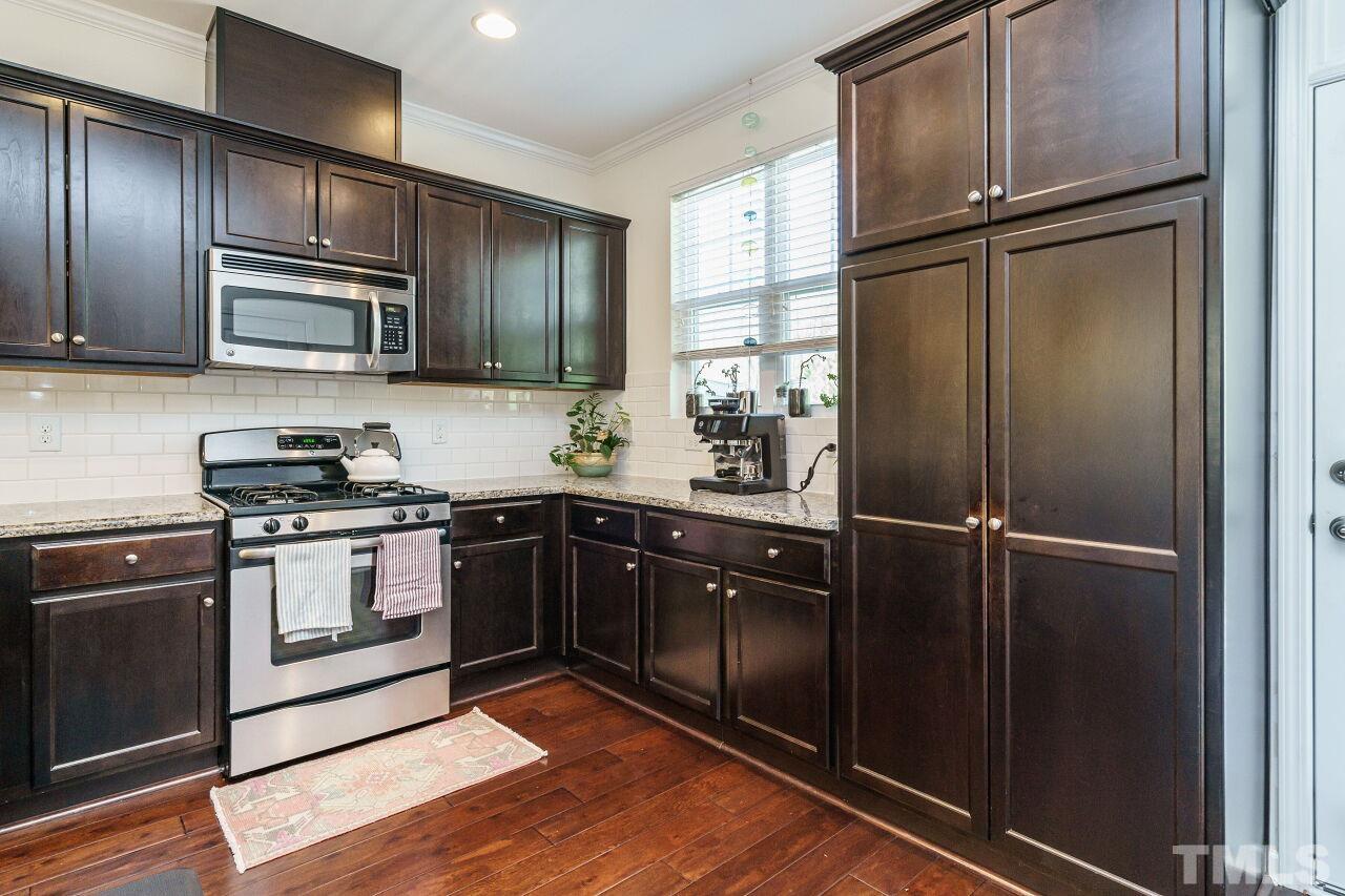 1533 Crafton Way Raleigh, NC 27607 - Photo 15 of 28 a kitchen with granite countertop stainless steel appliances and wooden cabinets