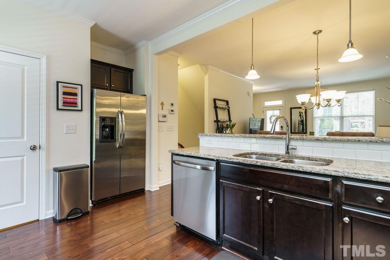 1533 Crafton Way Raleigh, NC 27607 - Photo 16 of 28 a kitchen with stainless steel appliances granite countertop a sink a refrigerator and wooden floor