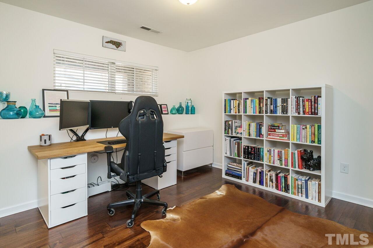 1533 Crafton Way Raleigh, NC 27607 - Photo 23 of 28 a view of a workspace with furniture and a bookshelf
