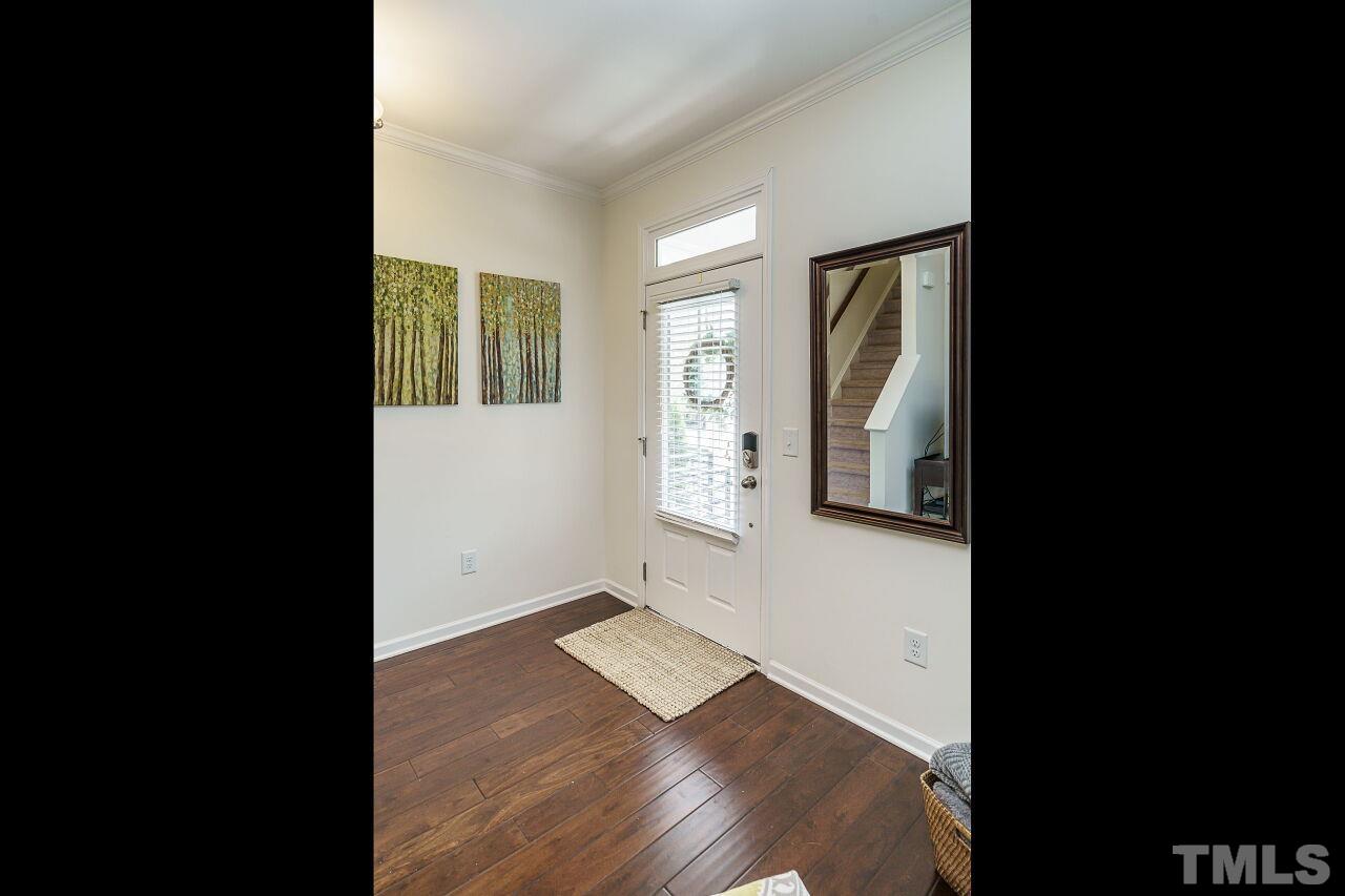 1533 Crafton Way Raleigh, NC 27607 - Photo 4 of 28 a view of an empty room with wooden floor and a window
