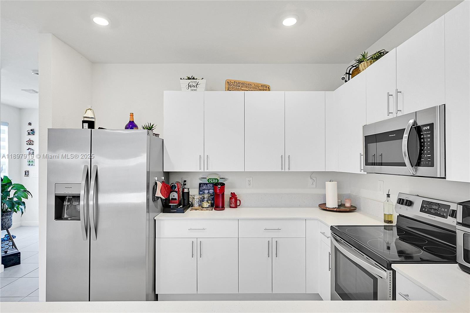 14832 Southwest 265th Street Homestead, FL 33032 - Photo 11 of 43 a kitchen with stainless steel appliances cabinets and a refrigerator