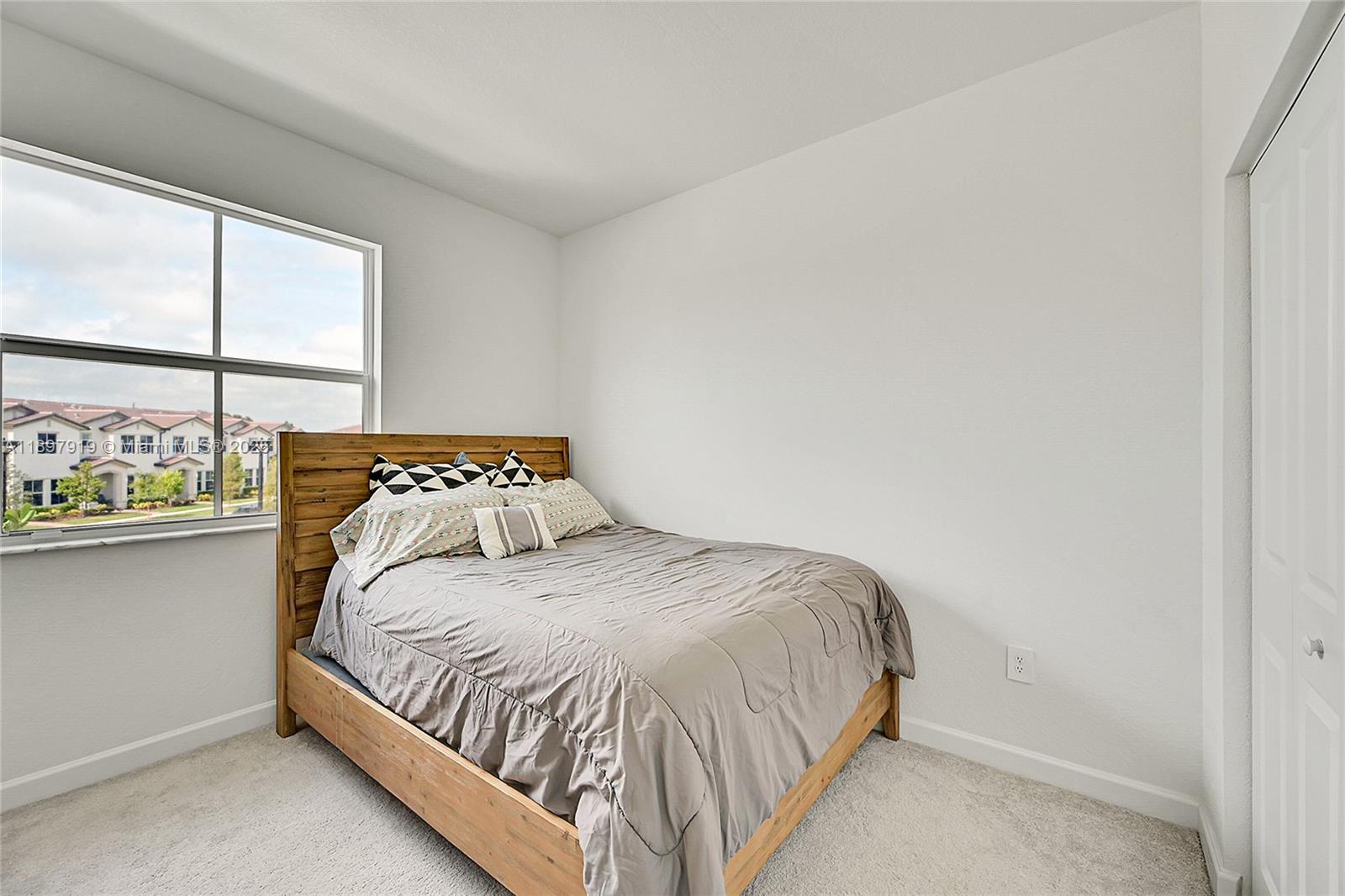 14832 Southwest 265th Street Homestead, FL 33032 - Photo 28 of 43 a bed sitting in a bedroom next to a window