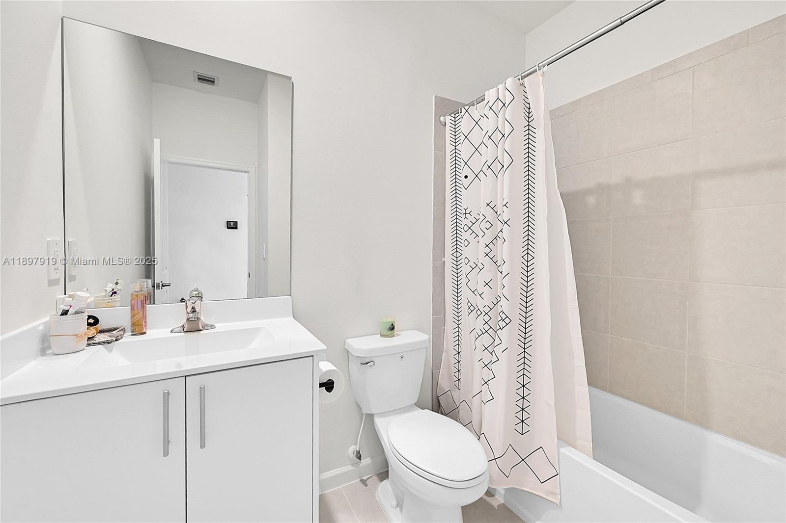 14832 Southwest 265th Street Homestead, FL 33032 - Photo 30 of 43 a bathroom with a sink a toilet a shower curtain and a mirror