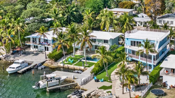 an aerial view of a house with swimming pool and lake view