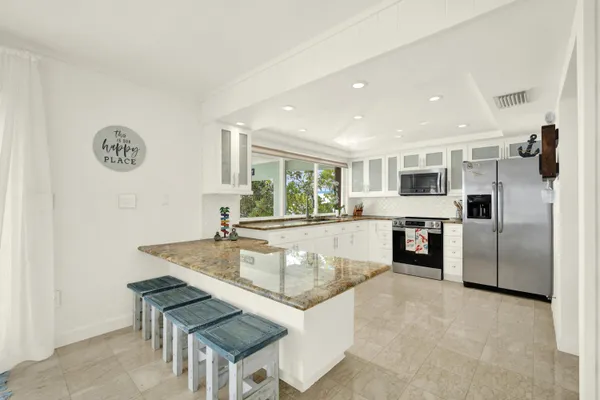 a kitchen with stainless steel appliances granite countertop a sink refrigerator and microwave