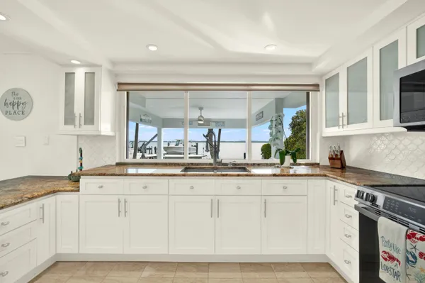 a kitchen with granite countertop a sink and cabinets