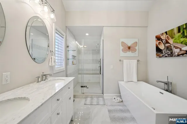 a spacious bathroom with a tub sink and mirror