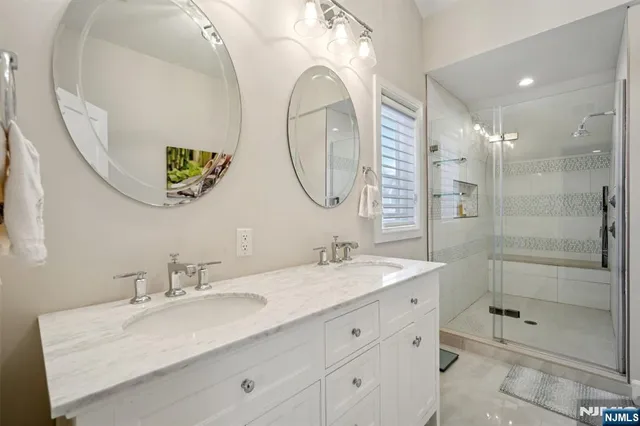 a bathroom with a granite countertop sink mirror and shower