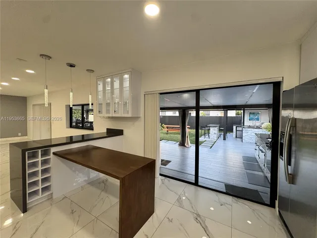 a large kitchen with kitchen island a sink a counter top space and stainless steel appliances