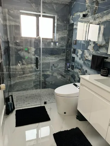 a bathroom with a shower sink and mirror