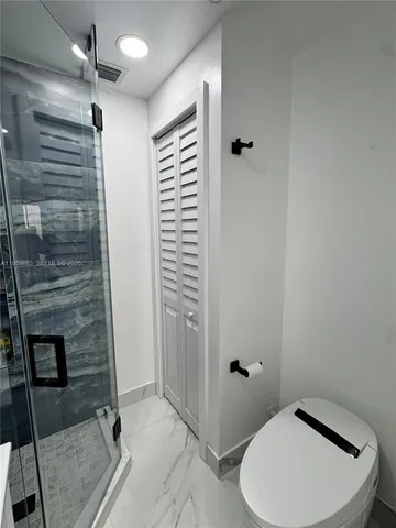 a kitchen with stainless steel appliances wooden floors and white cabinets