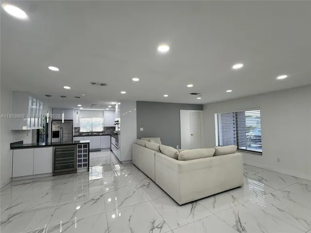 a living room with furniture and kitchen view