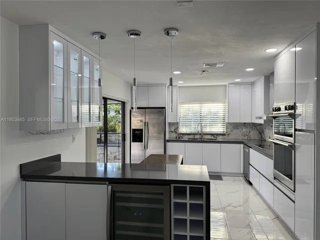 a kitchen with stainless steel appliances granite countertop a sink counter space cabinets and stainless steel appliances