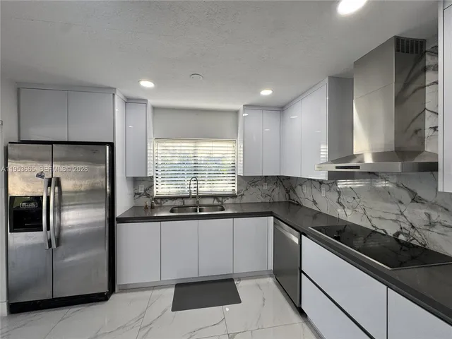 a kitchen with granite countertop a sink stainless steel appliances and cabinets