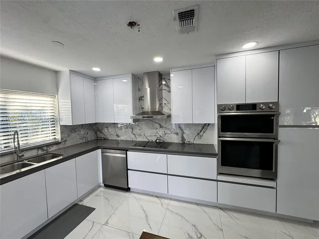 a kitchen with granite countertop stainless steel appliances and sink