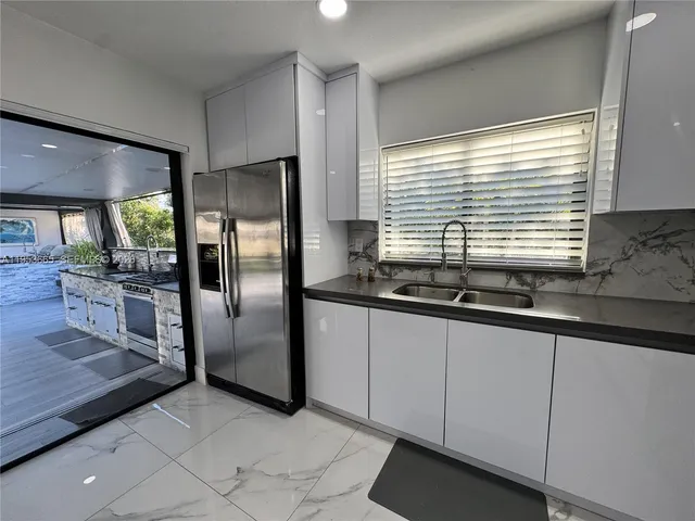 a kitchen with granite countertop a refrigerator and a sink