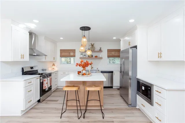 a kitchen with stainless steel appliances kitchen island granite countertop a sink stove and refrigerator