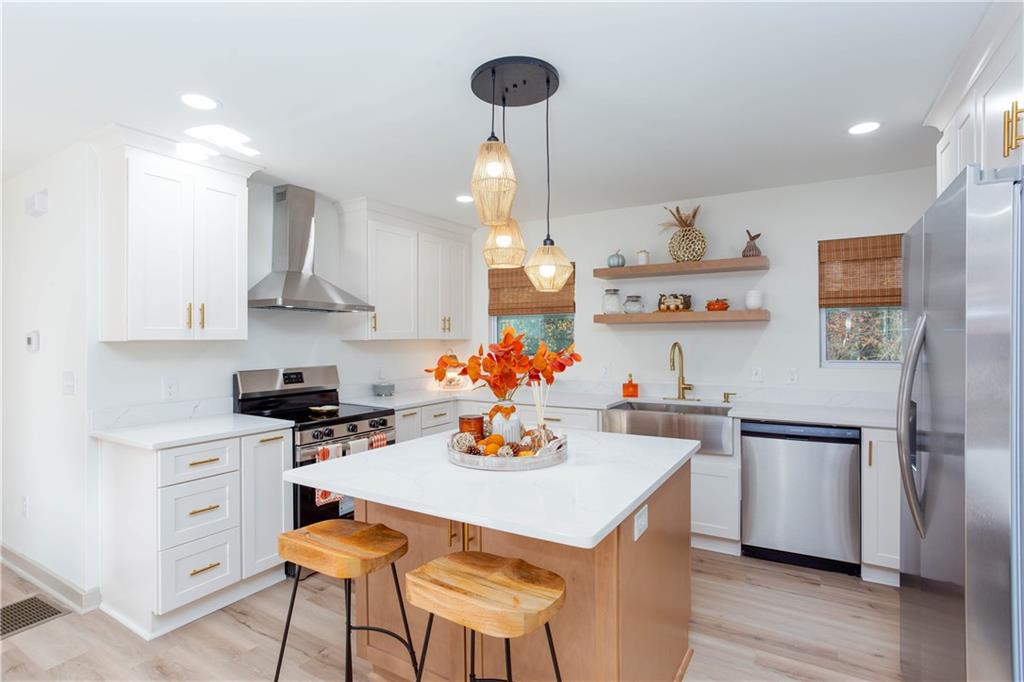 1560 North Columbia Place Decatur, GA 30032 - Photo 12 of 50 a kitchen with stainless steel appliances a dining table chairs stove and refrigerator