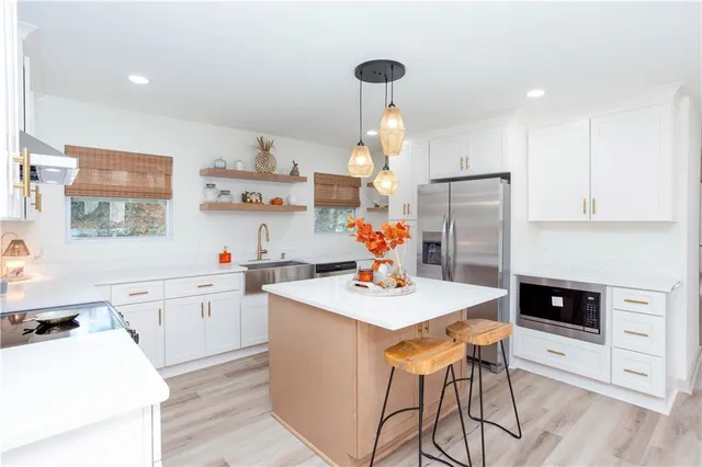 a kitchen with a sink a stove and white cabinets