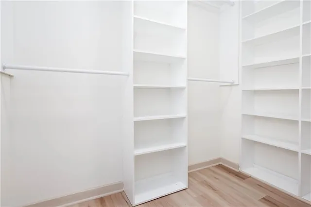 a view of walk in closet with empty racks