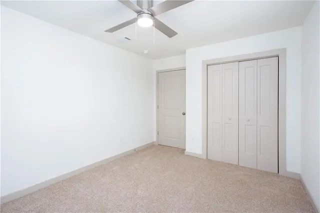 an empty room with a ceiling fan and a window