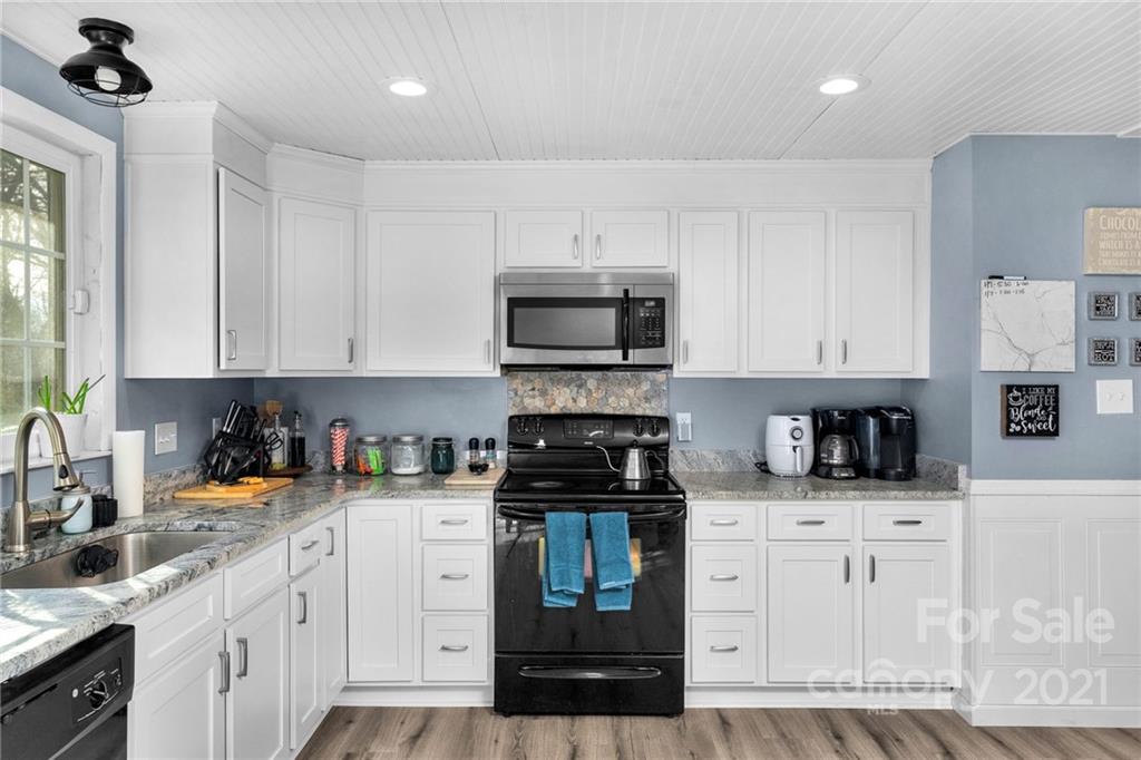 4800 Cheviot Road Charlotte, NC 28269 - Photo 12 of 34 a kitchen with granite countertop white cabinets and stainless steel appliances