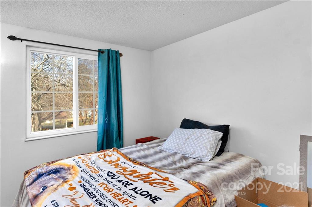 4800 Cheviot Road Charlotte, NC 28269 - Photo 18 of 34 a bedroom with a bed and wooden floor