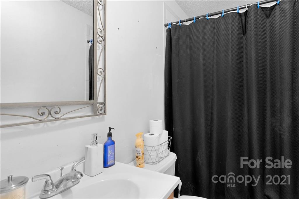 4800 Cheviot Road Charlotte, NC 28269 - Photo 19 of 34 a bathroom with a sink and a mirror