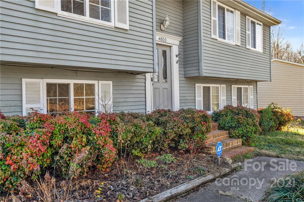 4800 Cheviot Road Charlotte, NC 28269 - Photo 5 of 34 a view of a house with potted plants and a bench