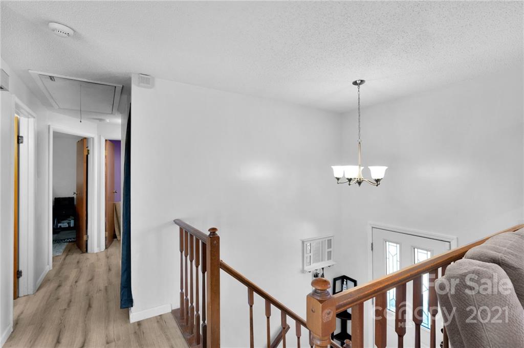 4800 Cheviot Road Charlotte, NC 28269 - Photo 7 of 34 a view of a hallway with wooden floor and chandelier