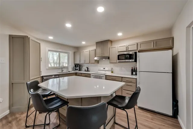 a kitchen with a dining table chairs refrigerator and cabinets