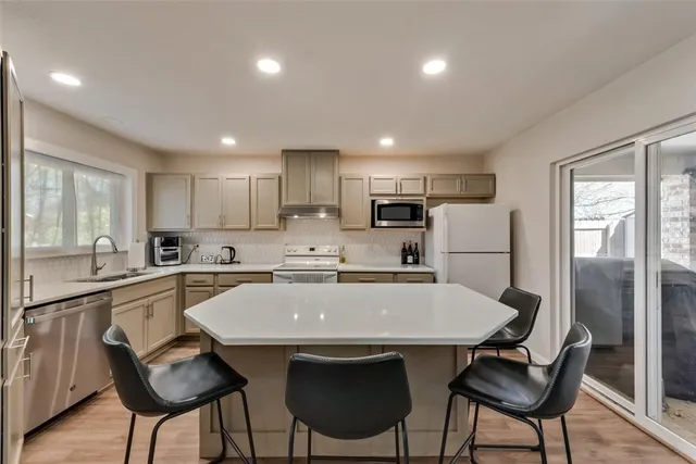 a kitchen with refrigerator and chairs