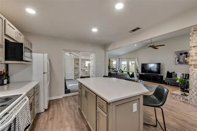 a kitchen with a counter space a sink appliances and cabinets
