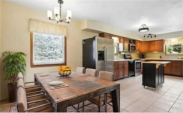 a kitchen with stainless steel appliances a dining table and chairs