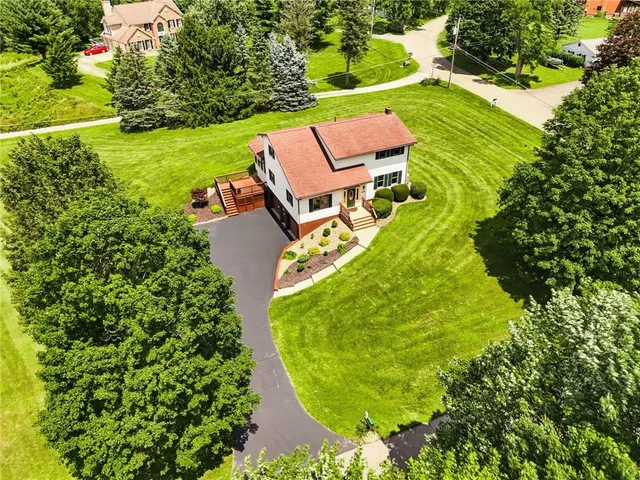 an aerial view of a house with a garden and swimming pool