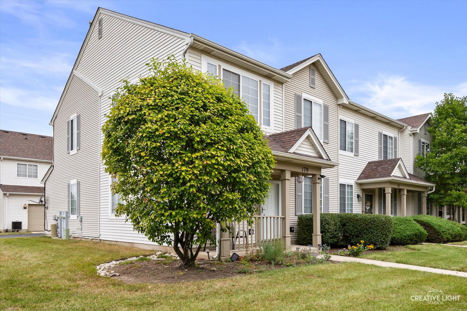179 Azalea Circle, Unit 179 Romeoville, IL 60446 - Photo 2 of 16 a front view of a house with a yard and garage