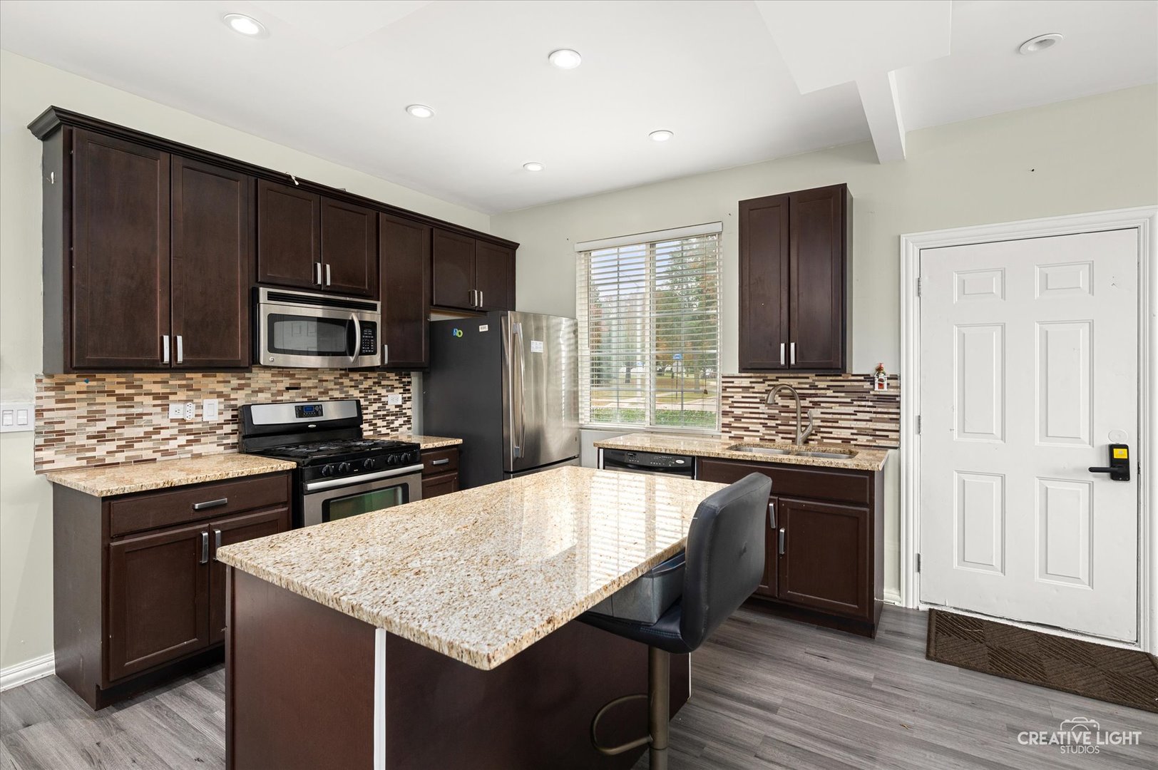 179 Azalea Circle, Unit 179 Romeoville, IL 60446 - Photo 3 of 16 a kitchen with kitchen island granite countertop wooden cabinets and stainless steel appliances