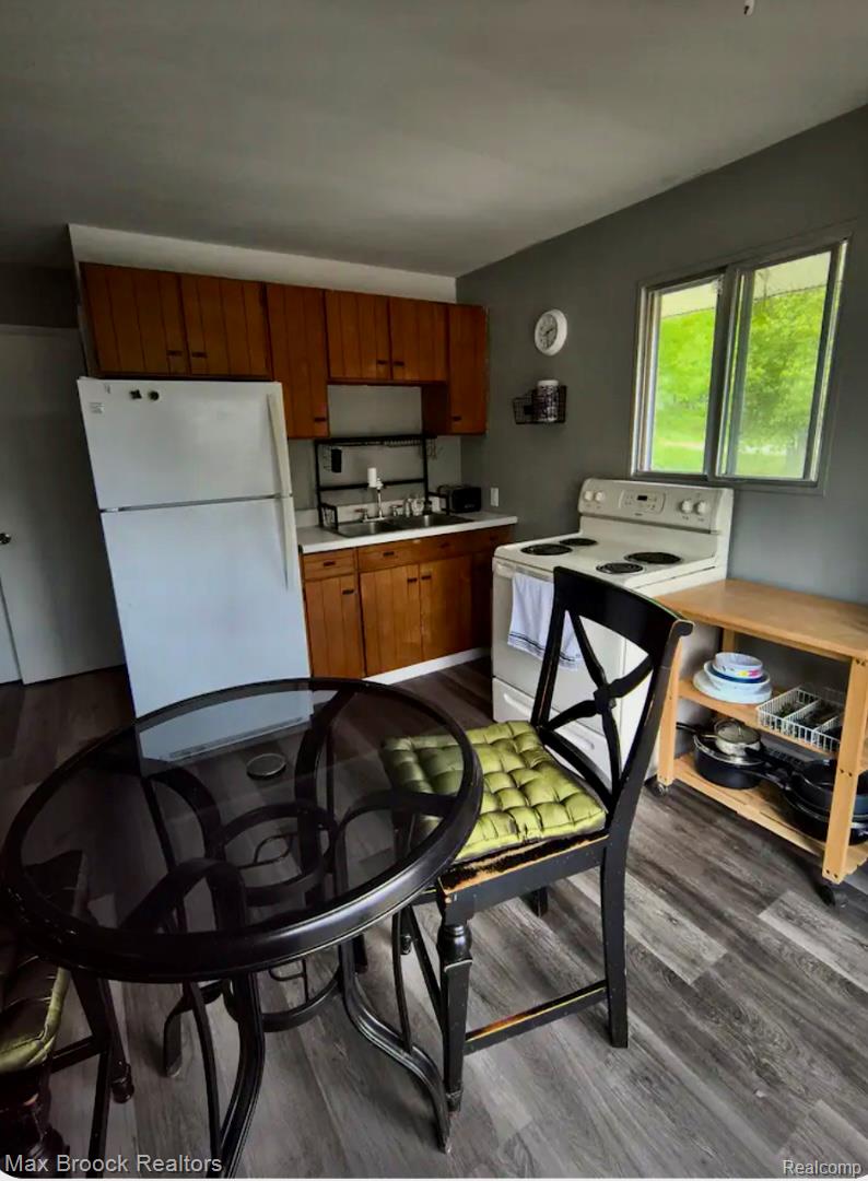 1392 Maple Grove Road Lapeer, MI 48446 - Photo 63 of 70 Kitchen featuring white appliances, dark wood-style floors, light countertops, and wood finish cabinetry