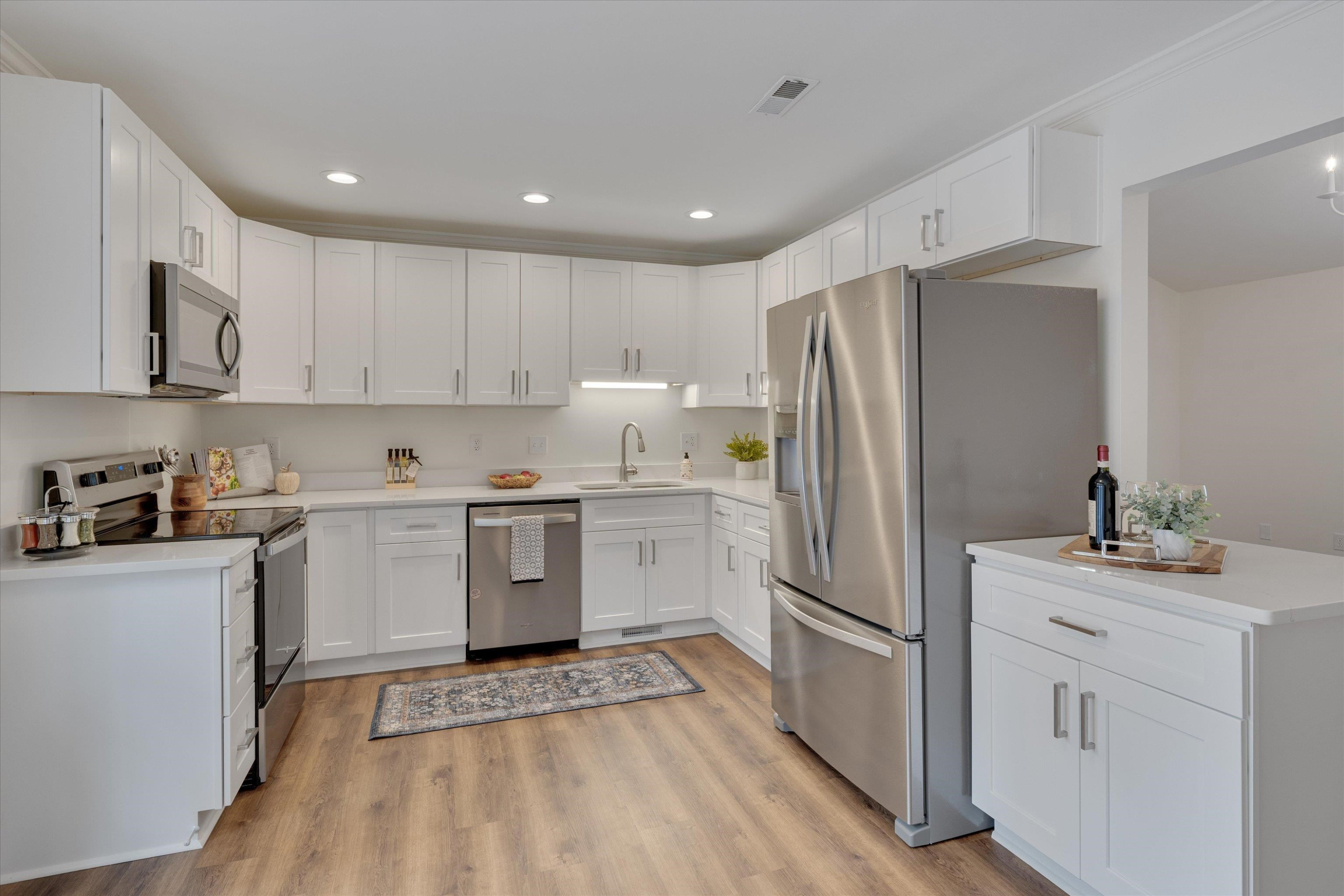 5500 Fortunes Ridge Drive, Unit 106D Durham, NC 27713 - Photo 13 of 30 a kitchen with white cabinets and stainless steel appliances