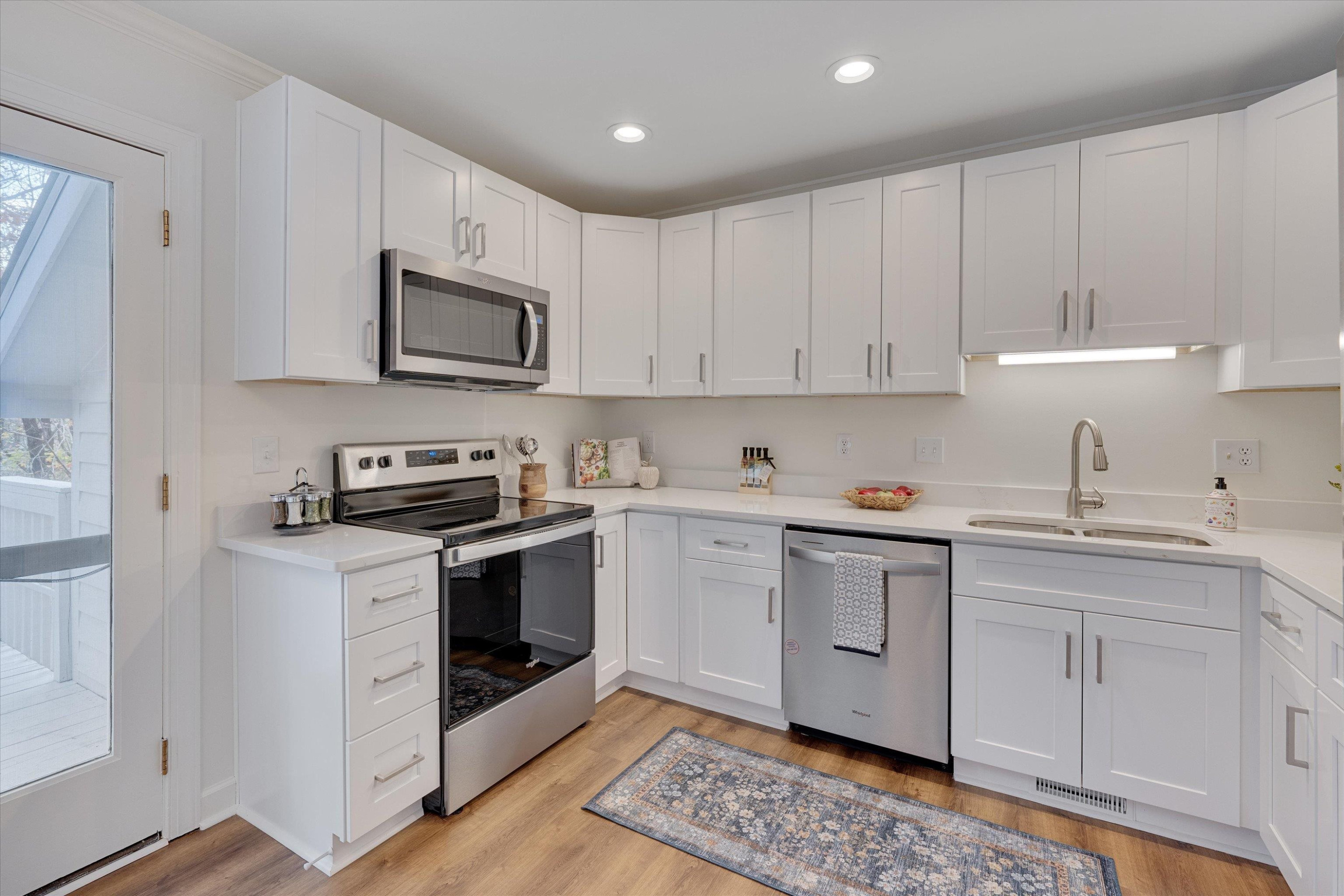 5500 Fortunes Ridge Drive, Unit 106D Durham, NC 27713 - Photo 14 of 30 a kitchen with stainless steel appliances granite countertop a sink a stove a microwave and cabinets