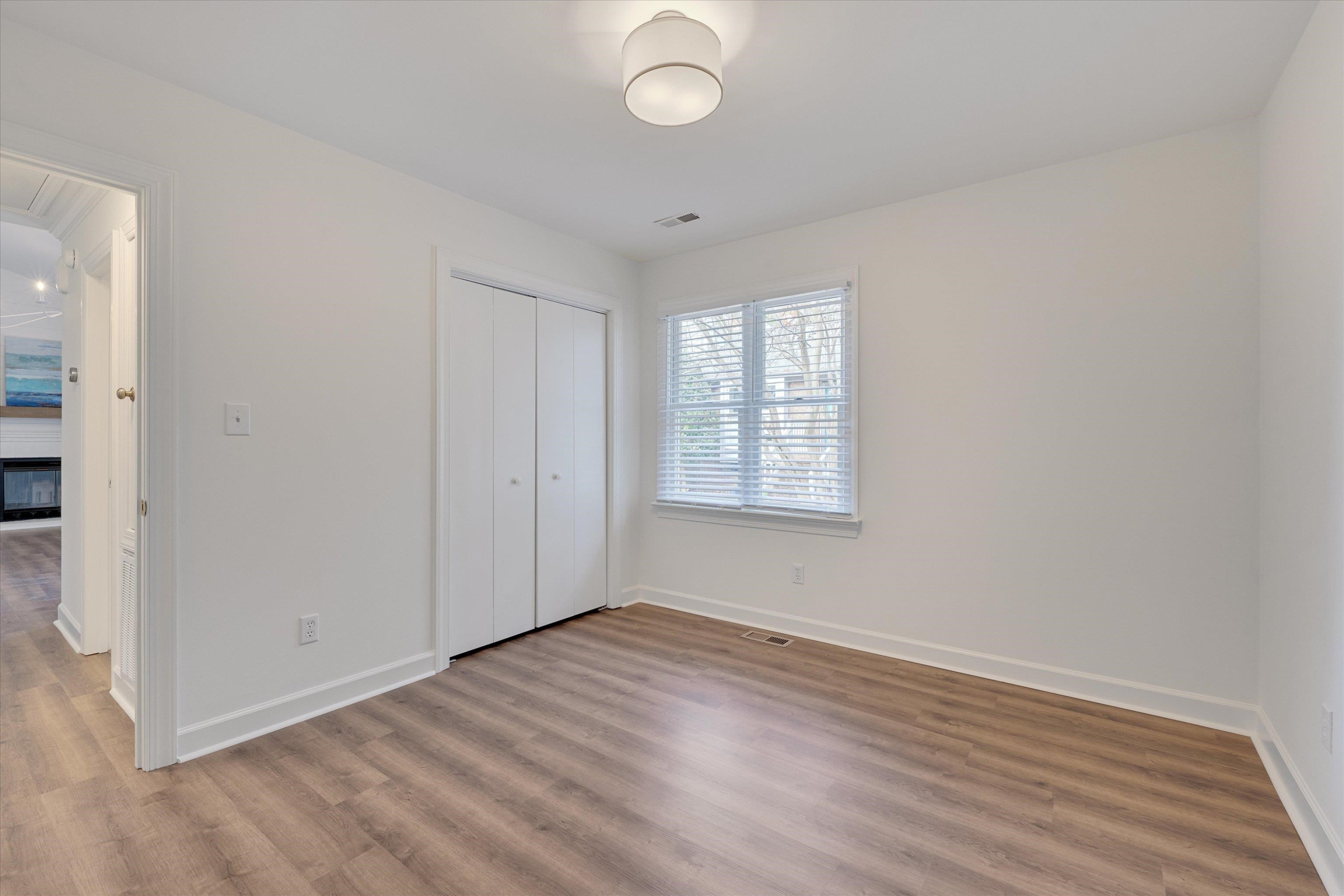 5500 Fortunes Ridge Drive, Unit 106D Durham, NC 27713 - Photo 19 of 30 an empty room with wooden floor and windows