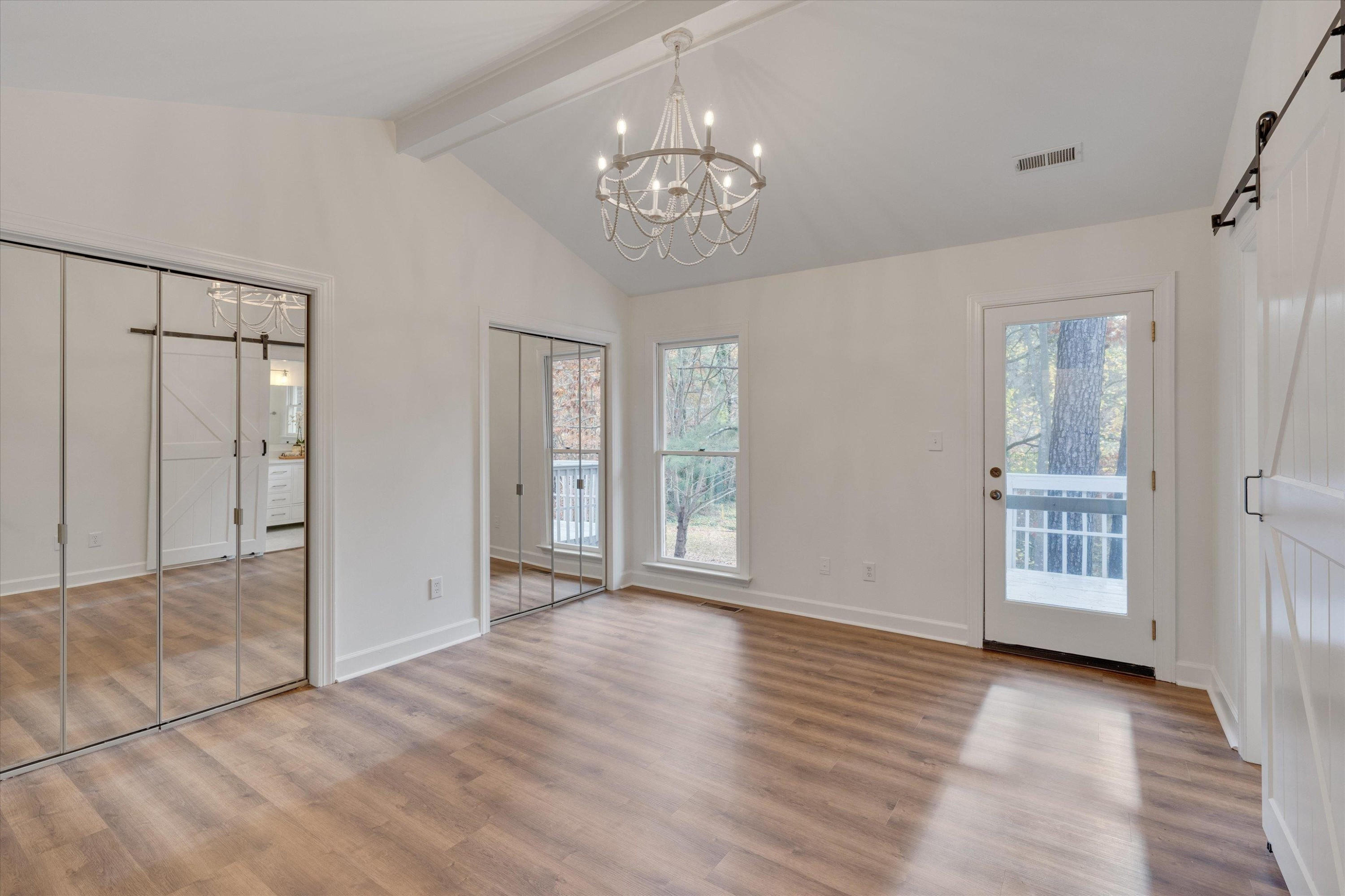 5500 Fortunes Ridge Drive, Unit 106D Durham, NC 27713 - Photo 20 of 30 a view of an empty room with wooden floor and a large window