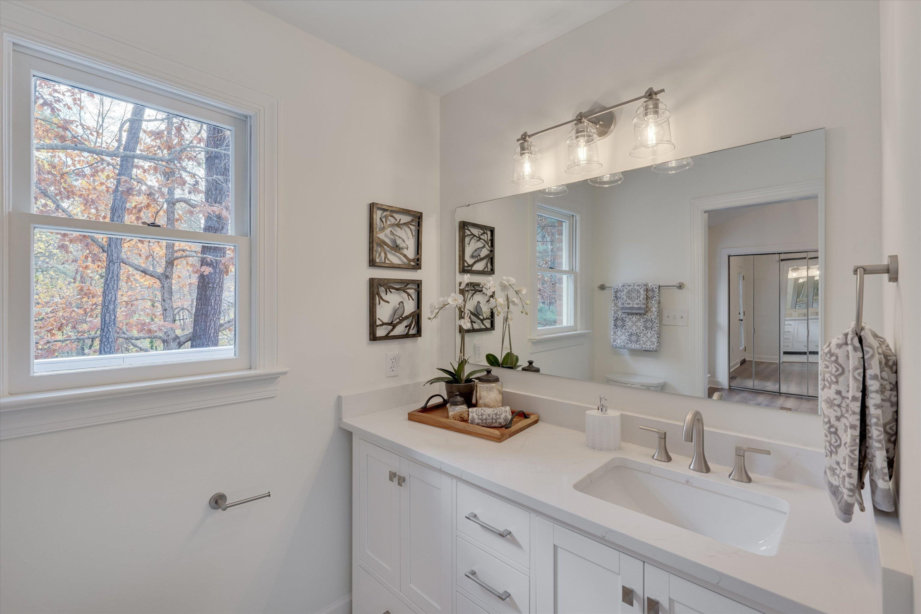 5500 Fortunes Ridge Drive, Unit 106D Durham, NC 27713 - Photo 23 of 30 a bathroom with a double vanity sink and a mirror