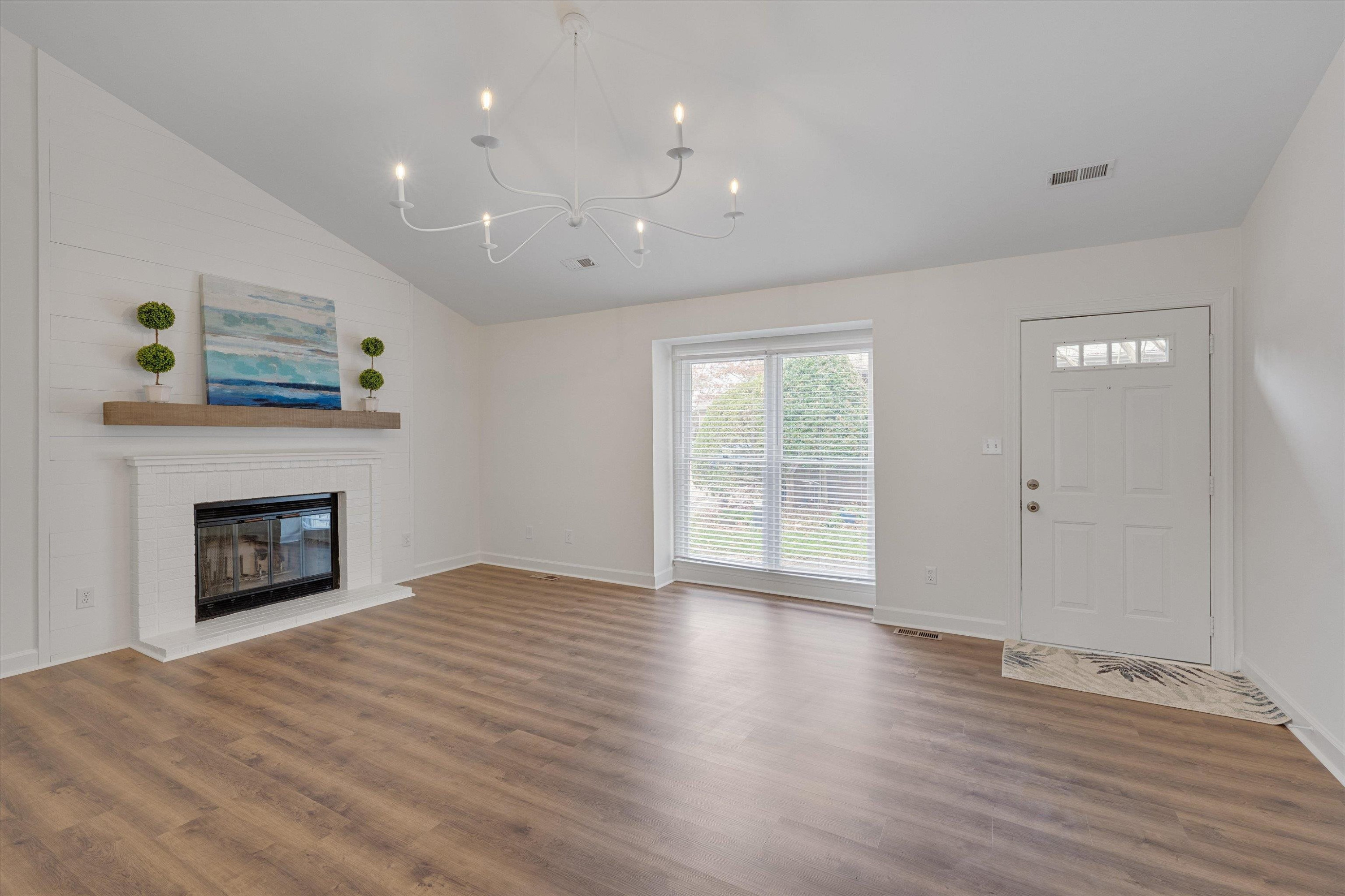 5500 Fortunes Ridge Drive, Unit 106D Durham, NC 27713 - Photo 5 of 30 an empty room with wooden floor a fireplace and windows