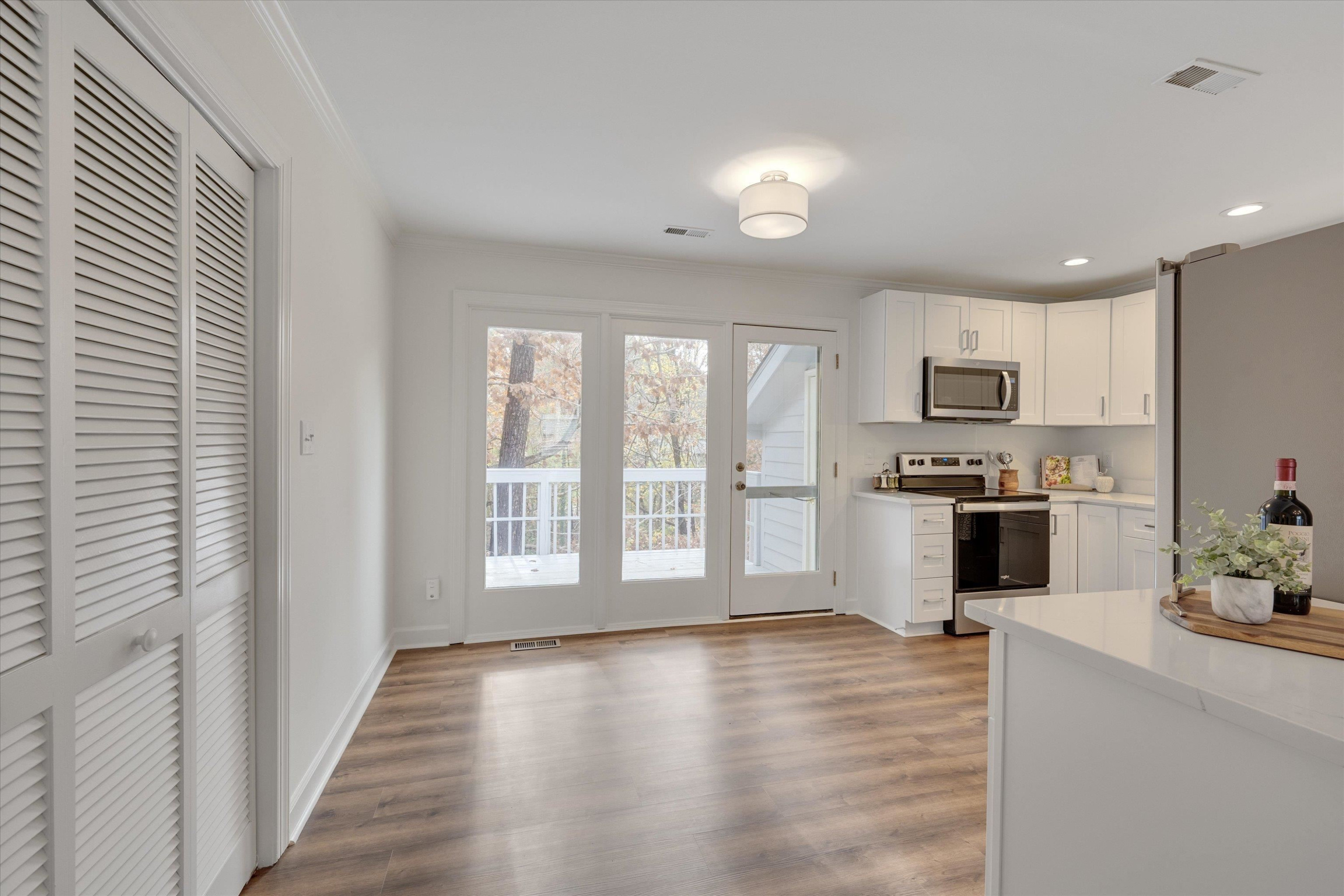 5500 Fortunes Ridge Drive, Unit 106D Durham, NC 27713 - Photo 10 of 30 a large kitchen with white cabinets and wooden floor