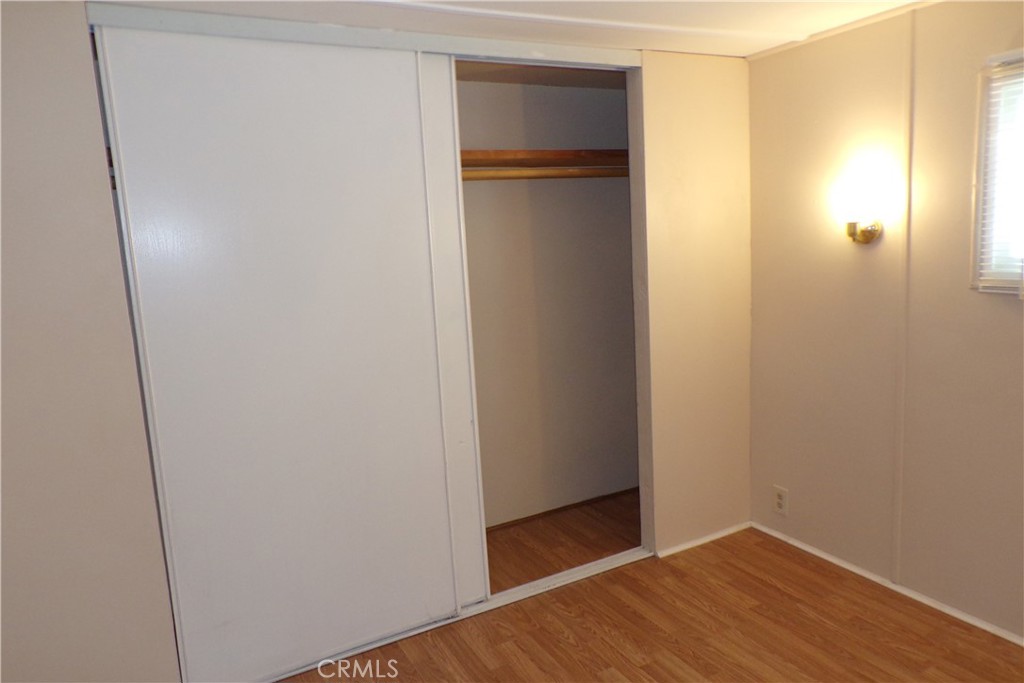 12710 3rd Street, Unit 57 Yucaipa, CA 92399 - Photo 11 of 13 a view of an empty room with closet and wooden floor